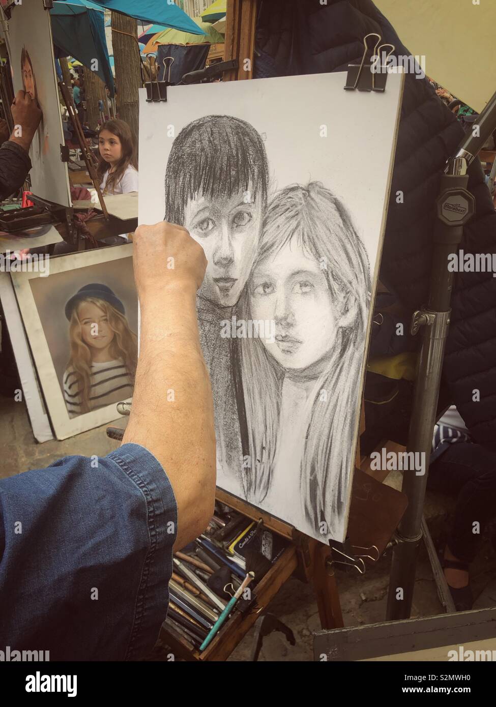 Montmartre Artist Drawing Portrait Of Boy And Girl In Black And