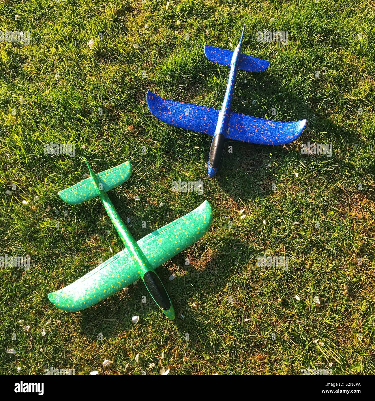 Foam toy throwing airplanes on grass outside. - Smartphone Captured Stock Image