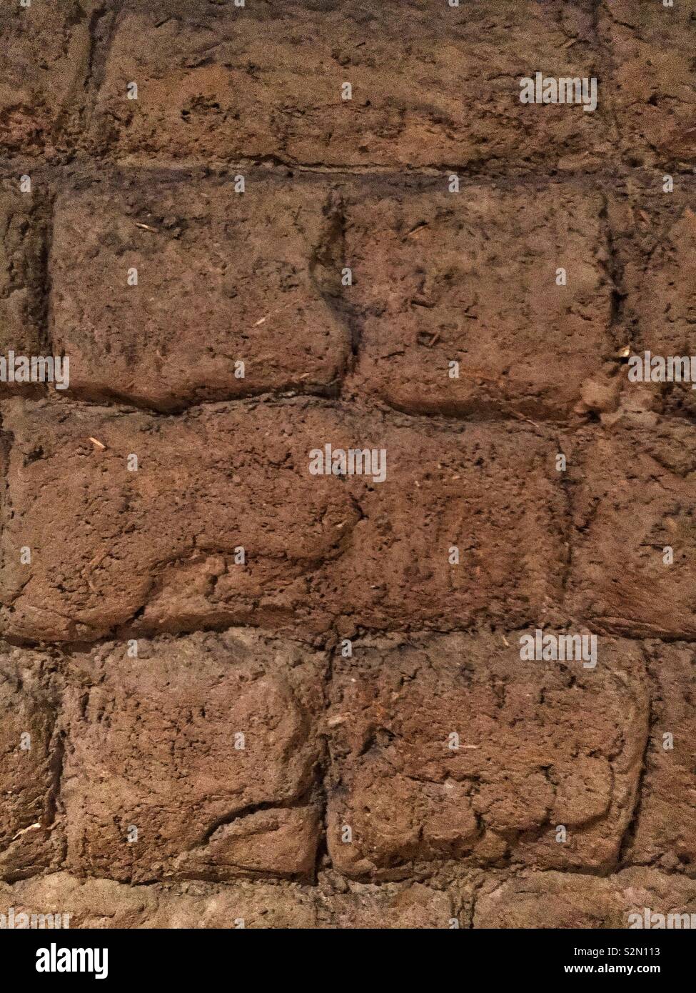 Clay mud bricks packed, dried, and strong as a wall building material. Stock Photo