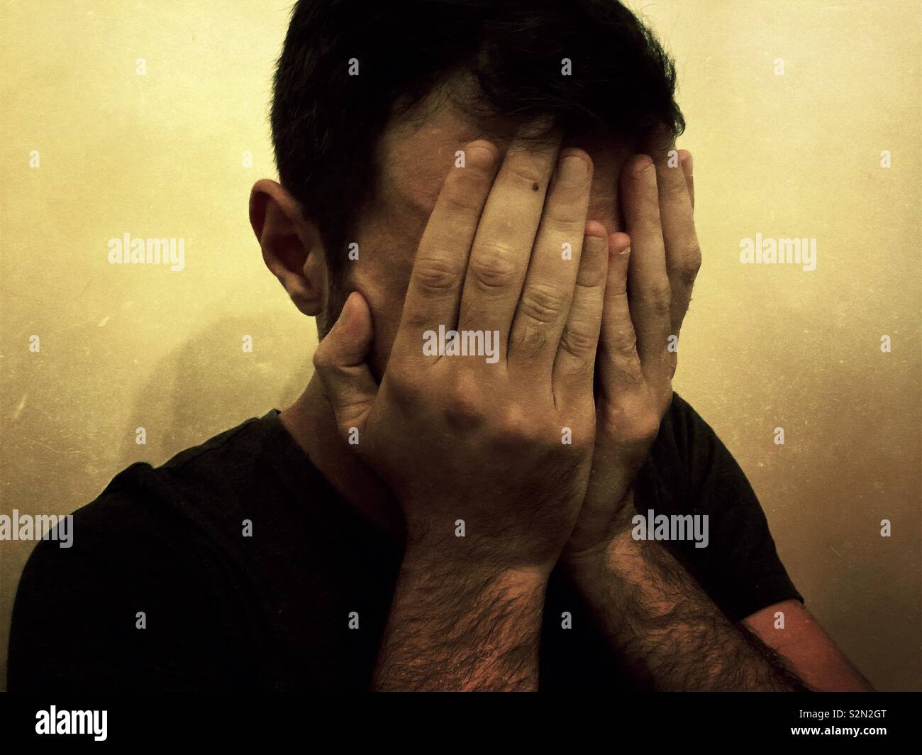 Depressed man hiding face with hands Stock Photo