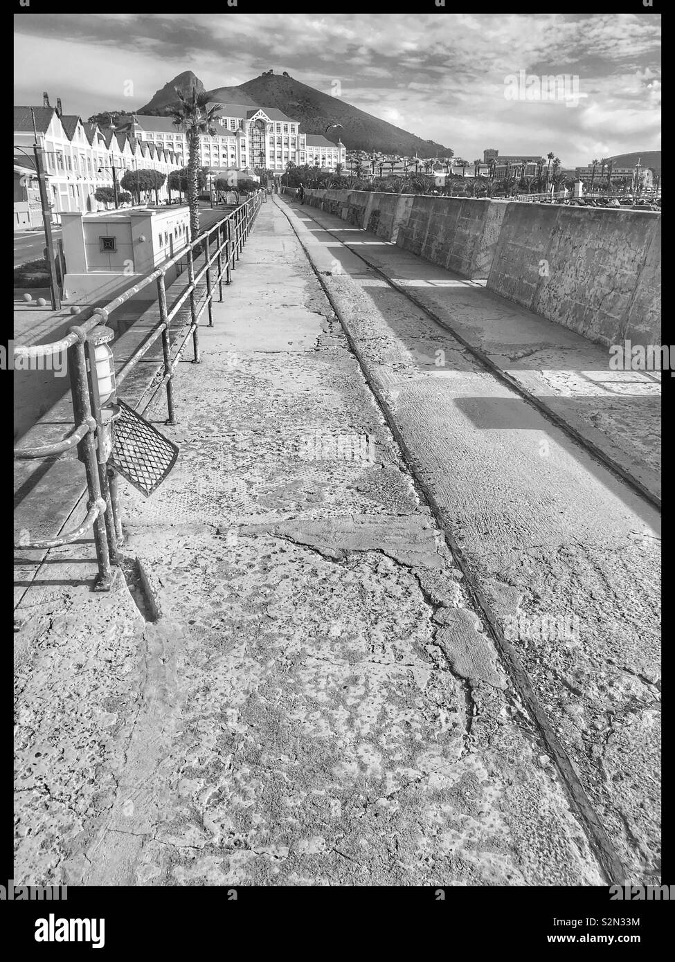 Walkway at V&A Waterfront with Table Bay Hotel in background, Cape Town, South Africa. Black and white photo. - Smartphone Captured Stock Image
