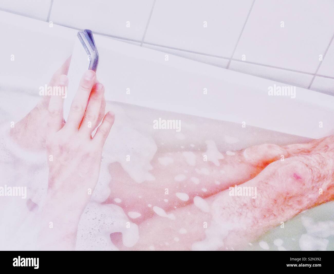 Man using smartphone in the bath - Smartphone Captured Stock Image