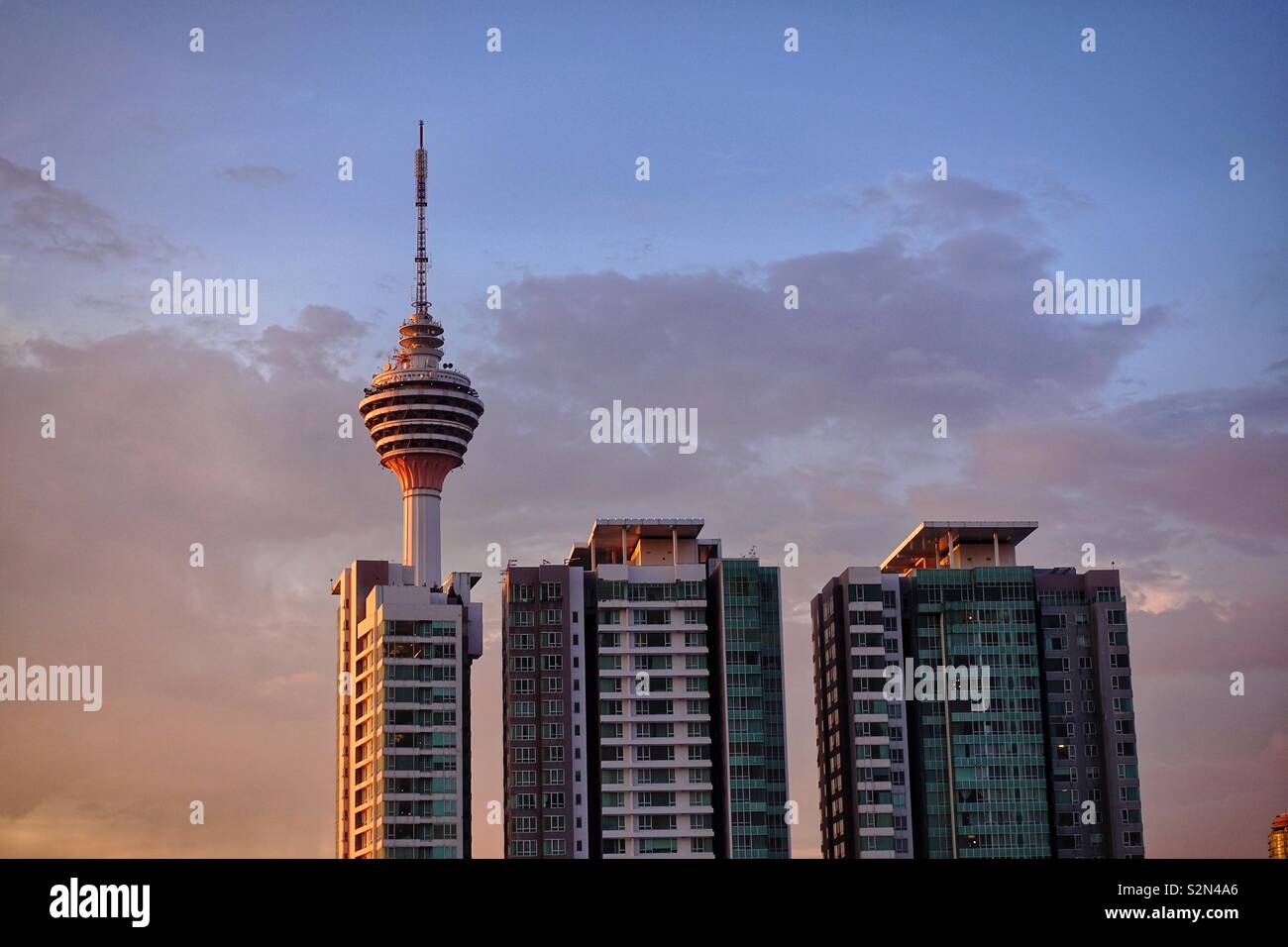 Three houses and a communications tower. In Asia. By sunset. Beautiful colors, calm atmosphere. Stock Photo