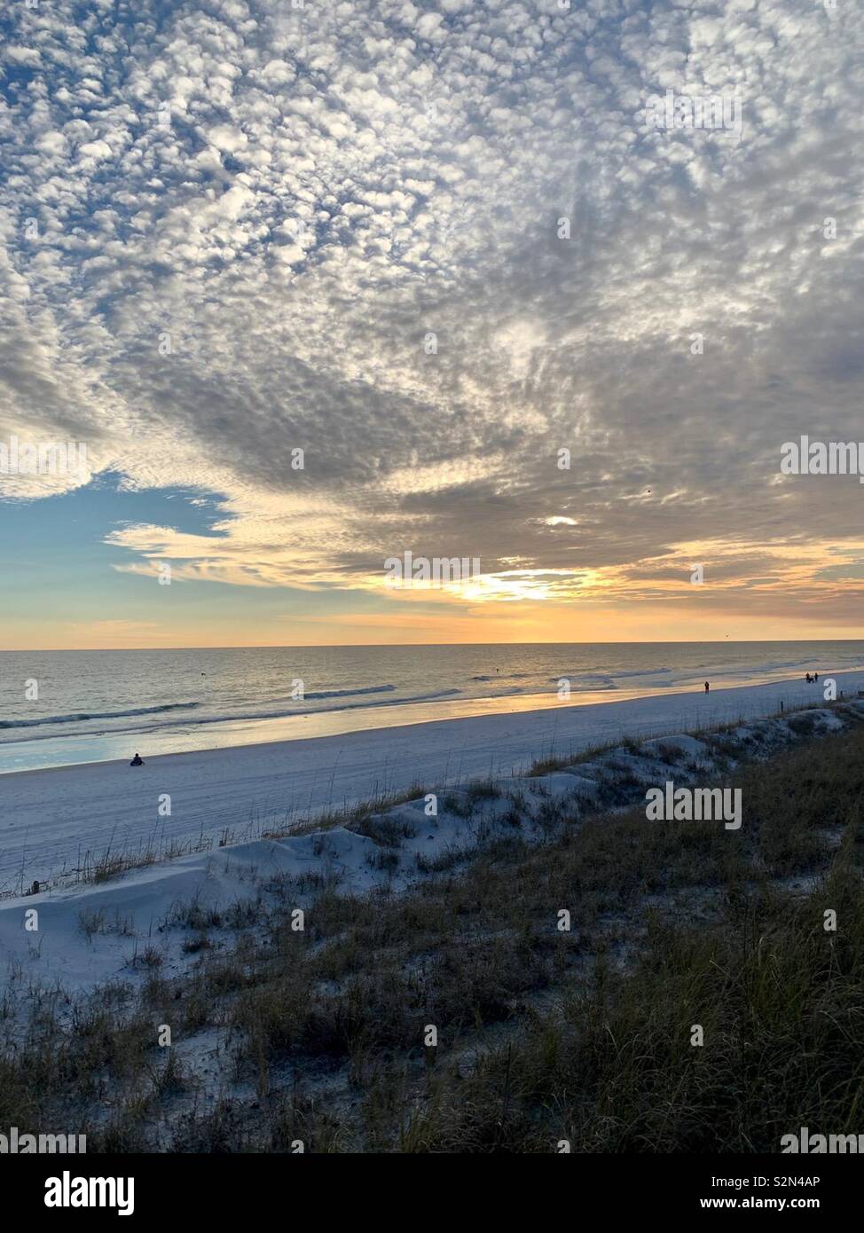 Sunset on beach with large area of white clouds, waves, sand, Florida. - Smartphone Captured Stock Image