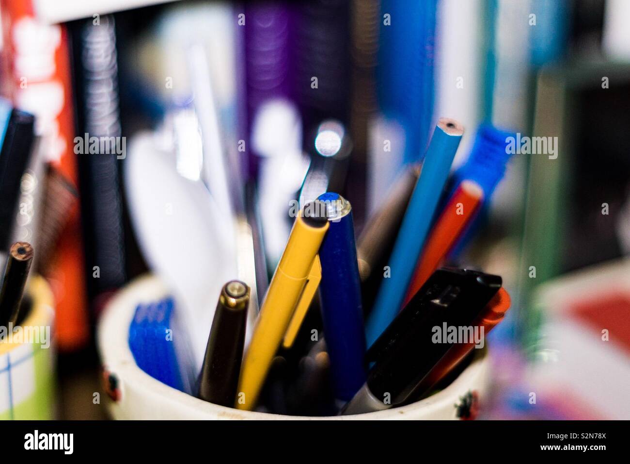 Brightly coloured pens and pencils on a bookcase Stock Photo Alamy