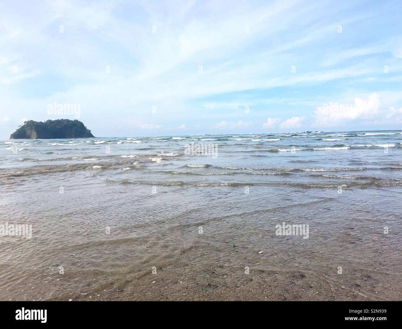 View of the ocean from the beach at low tide in Samara, Costa Rica. - Smartphone Captured Stock Image
