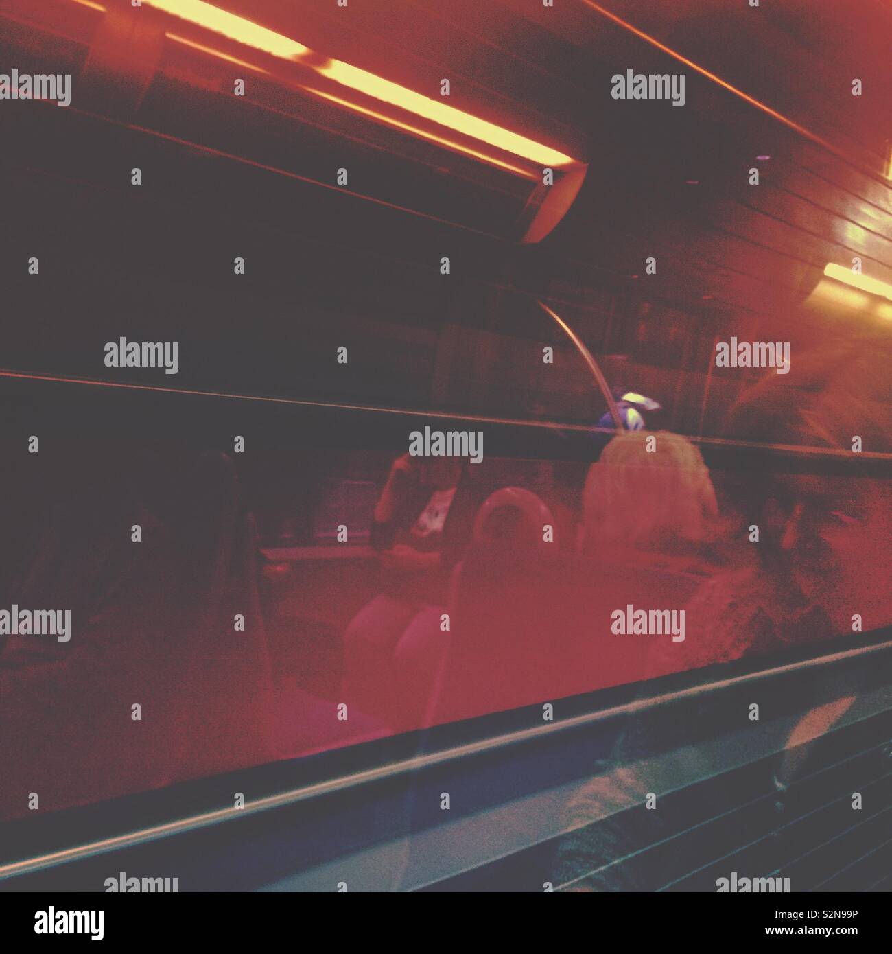 A moving train window and abstract reflections in red - Smartphone Captured Stock Image