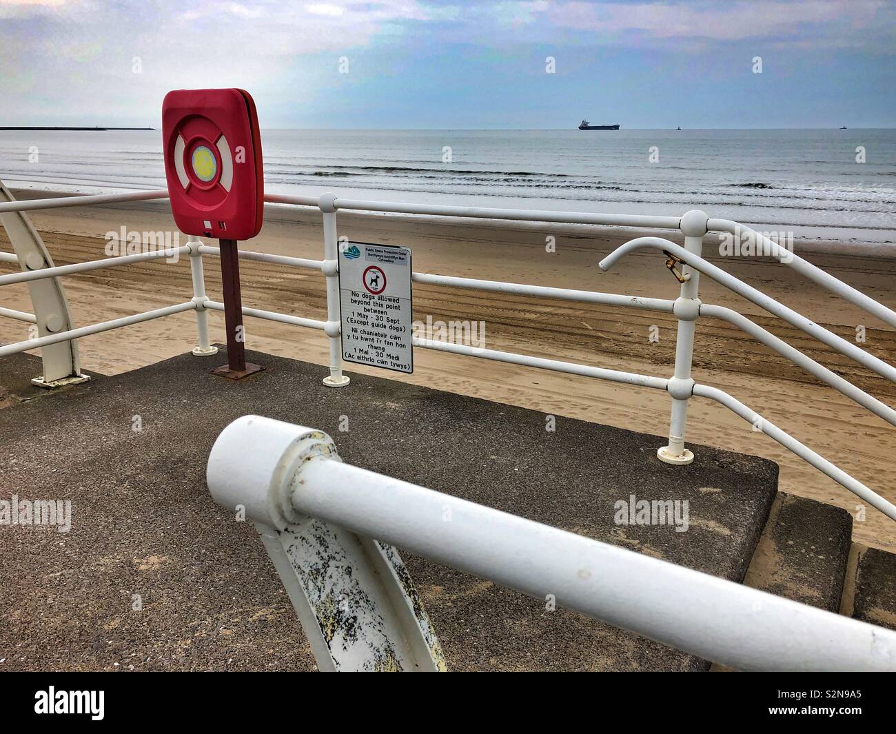 Life buoy on Aberavon seafront, Port Talbot, South Wales. Ship out to sea. May. - Smartphone Captured Stock Image