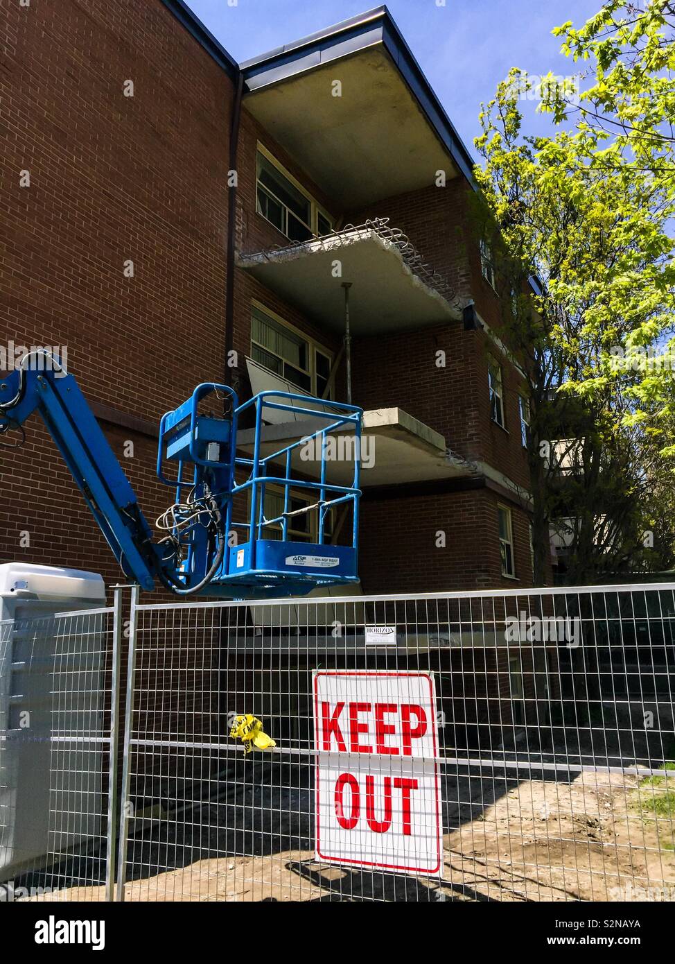 Keep out sign on a metal fence. Safety feature. Local bylaw. Structured dismantling. Partial demolition. Fenced. Enclosed. Area. No people. - Smartphone Captured Stock Image