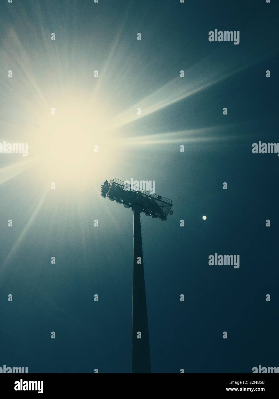 Low angle view of stadium lights against the sun at noon - Smartphone Captured Stock Image