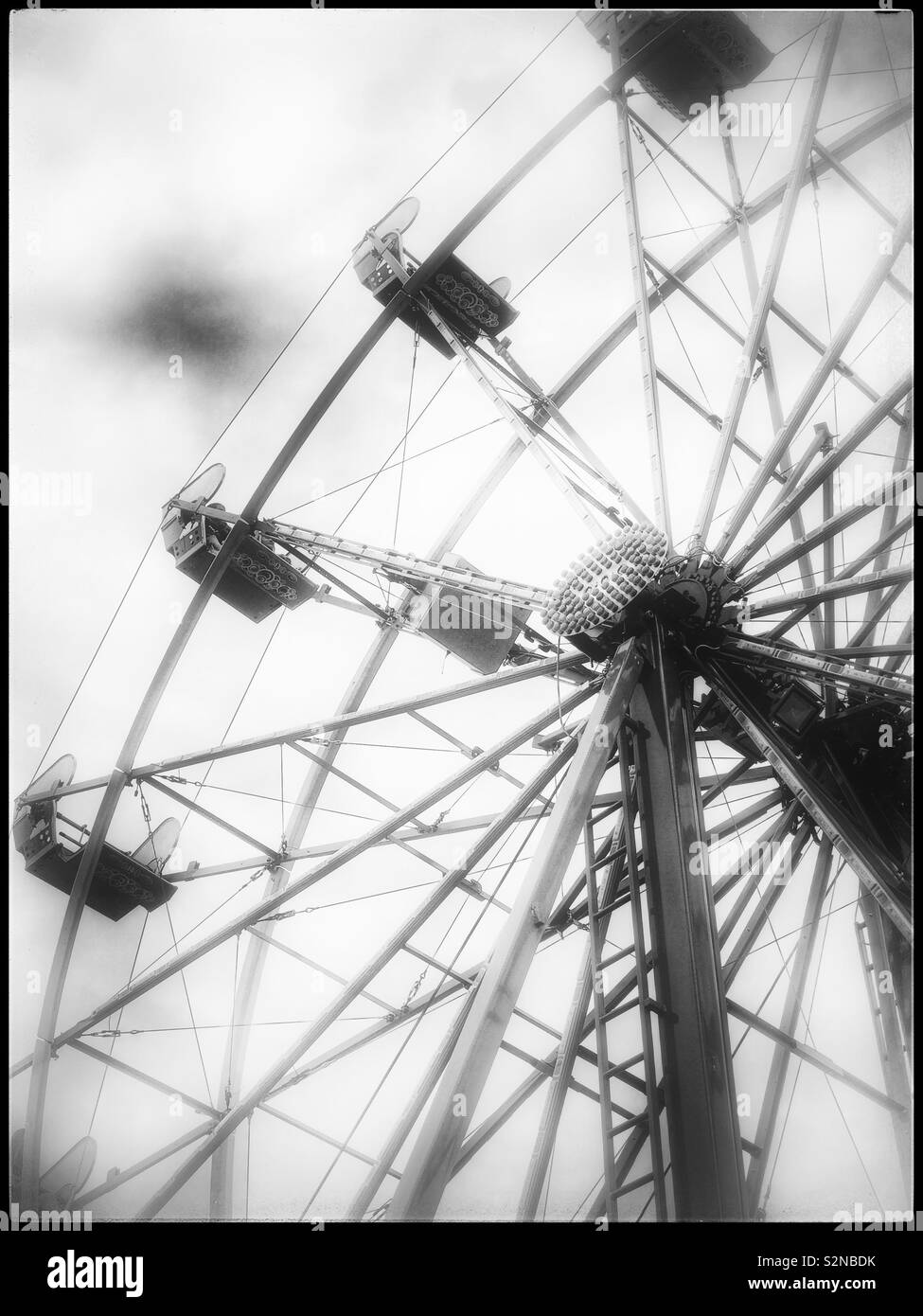 Street carnival Ferris wheel ride in moody black and white - Smartphone Captured Stock Image