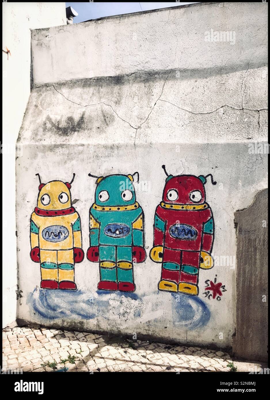 Graffiti or Art? Three extra-terrestrials painted onto a grimy white wall are standing in front of you. What are they looking at? What are they thinking? Photo Credit - © COLIN HOSKINS. - Smartphone Captured Stock Image