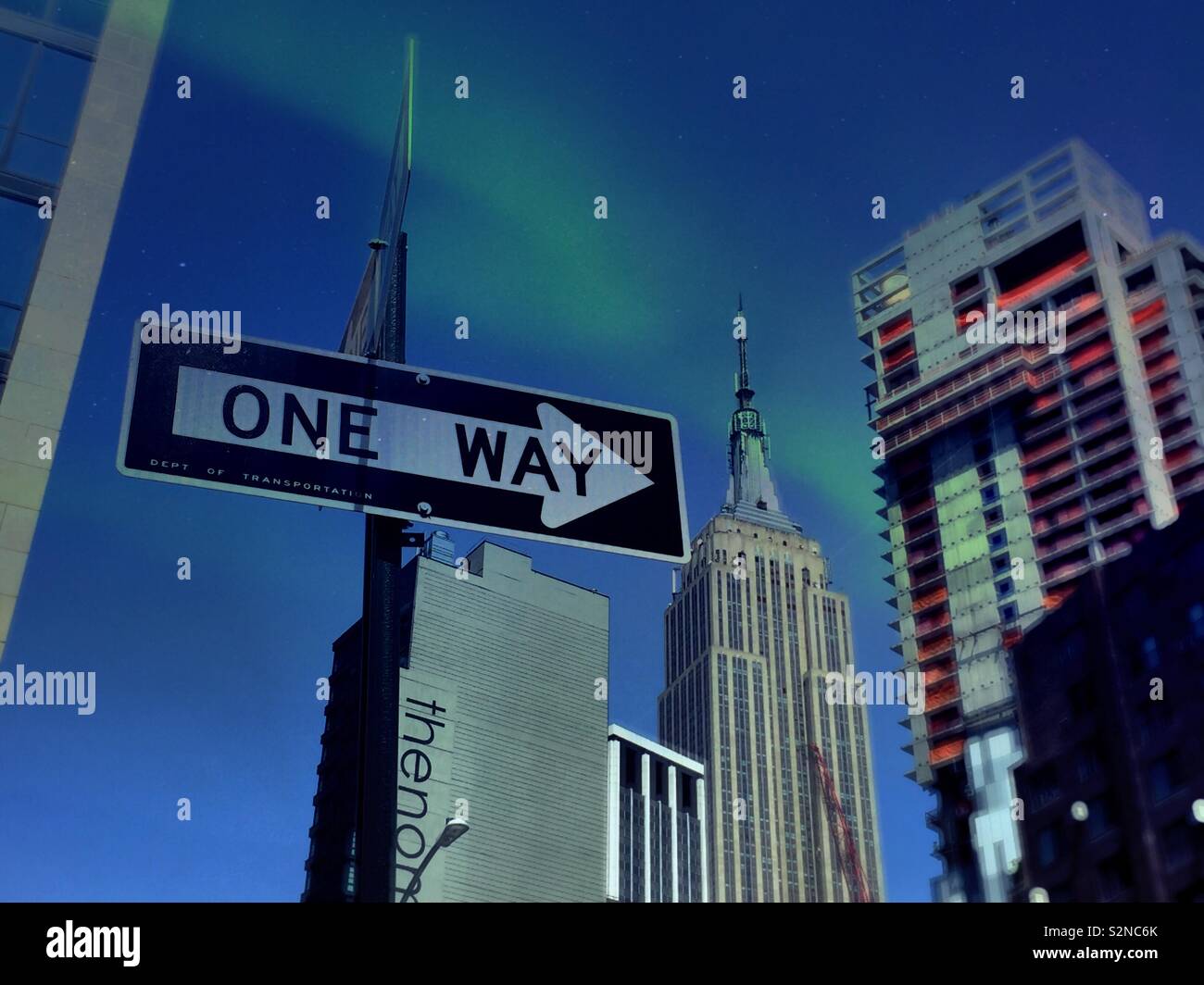 The Empire State building and a high-rise under construction as seen from a one-way street in Chelsea, NYC, USA - Smartphone Captured Stock Image