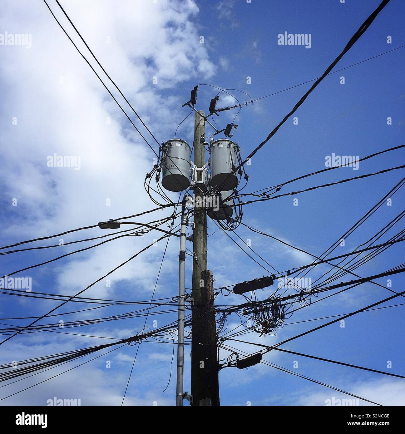 Utility pole with telephone and electric wires stretching in all directions Stock Photo