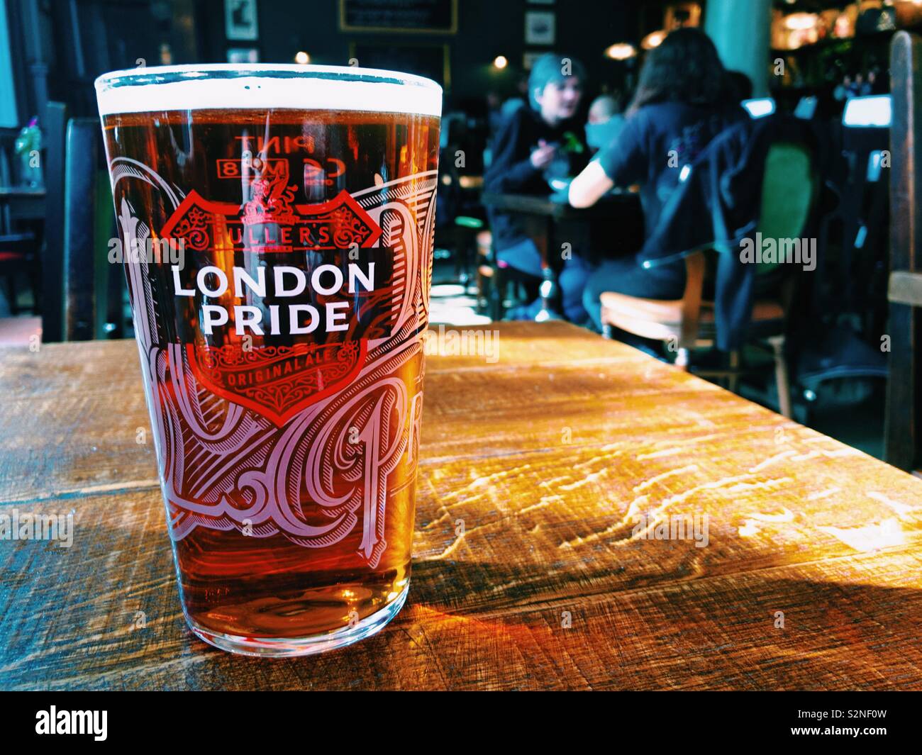 A pint of Fuller’s London Pride beer on a table in a pub Stock Photo