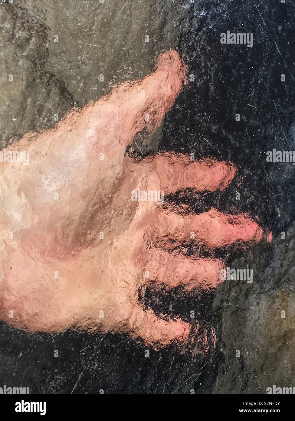 The left hand under a textured glass table. - Smartphone Captured Stock Image