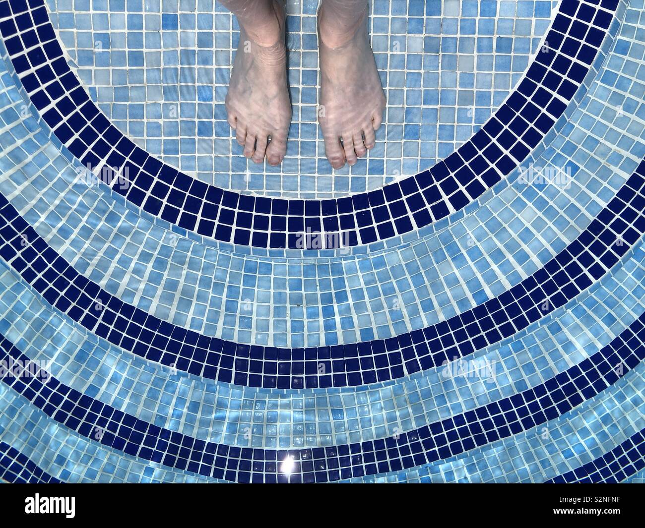 Feet under water in top step of swimming pool - Smartphone Captured Stock Image