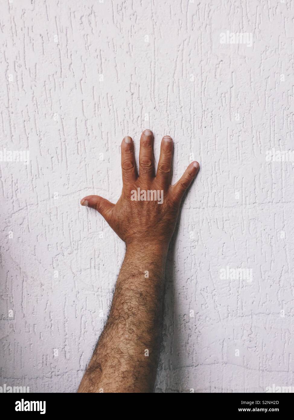 Man’s hand against wall - Smartphone Captured Stock Image