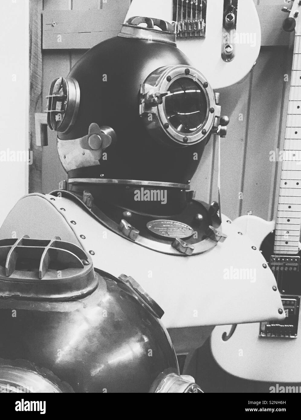 Black and white photo of vintage deep sea diving helmet on display Stock Photo