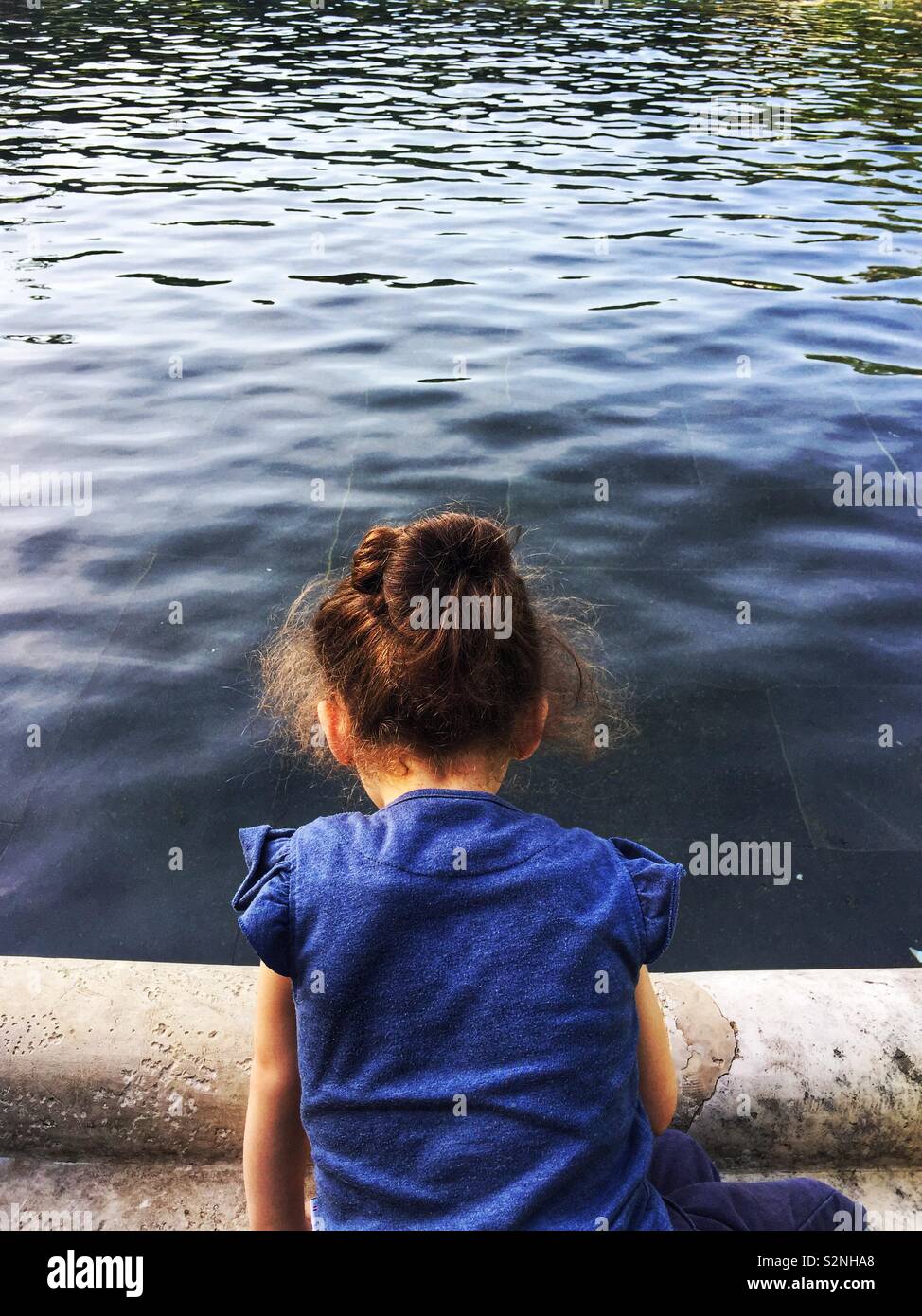 Rear view of little girl by the water Stock Photo