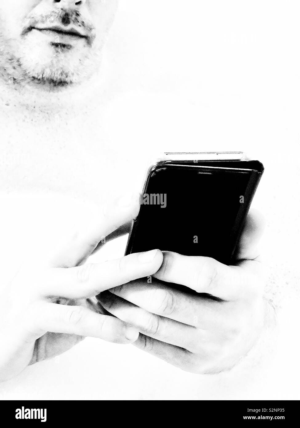 Lower half of face of unshaven man using smartphone Stock Photo