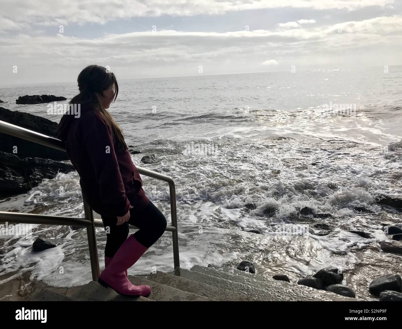 Child looking out to sea while the tide rises. Barry Island beach Stock Photo Alamy