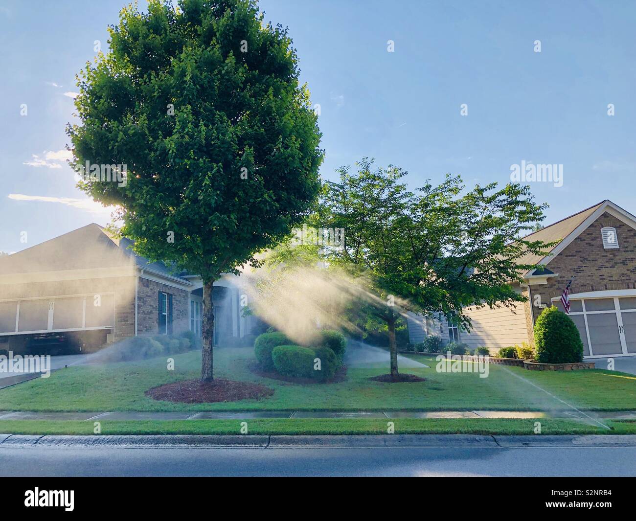 Morning sprinklers catching sunlight Stock Photo Alamy