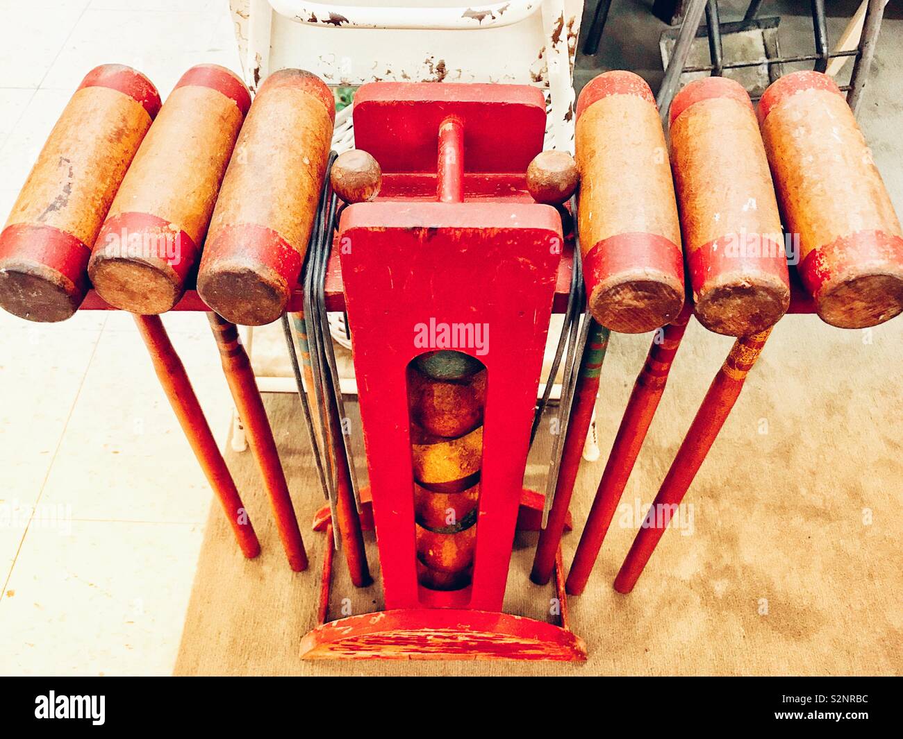 Red is predominant color in photo of vintage wooden croquet set with stand - Smartphone Captured Stock Image