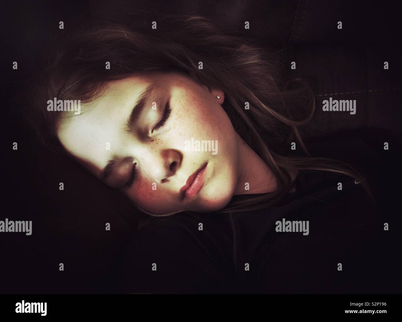 Face highlighted by light of sleeping preteen girl - Smartphone Captured Stock Image