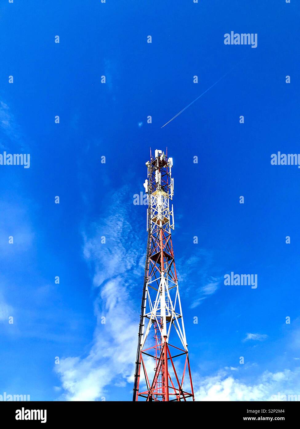 Tower with communication antennas against the blue sky with clouds - Smartphone Captured Stock Image