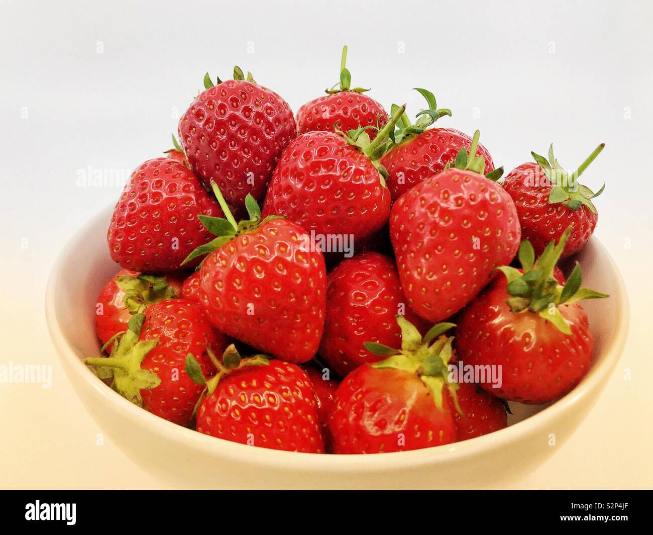 Bowl of fresh ripe strawberries on a plain white background Stock Photo ...