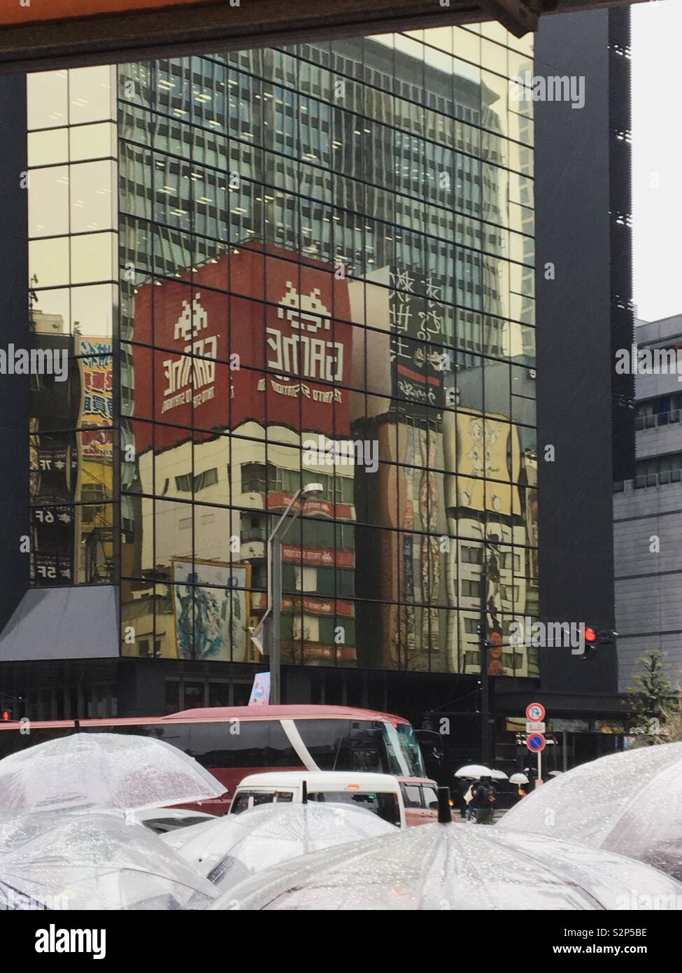 Reflection on a skyscraper, above umbrellas - Smartphone Captured Stock Image