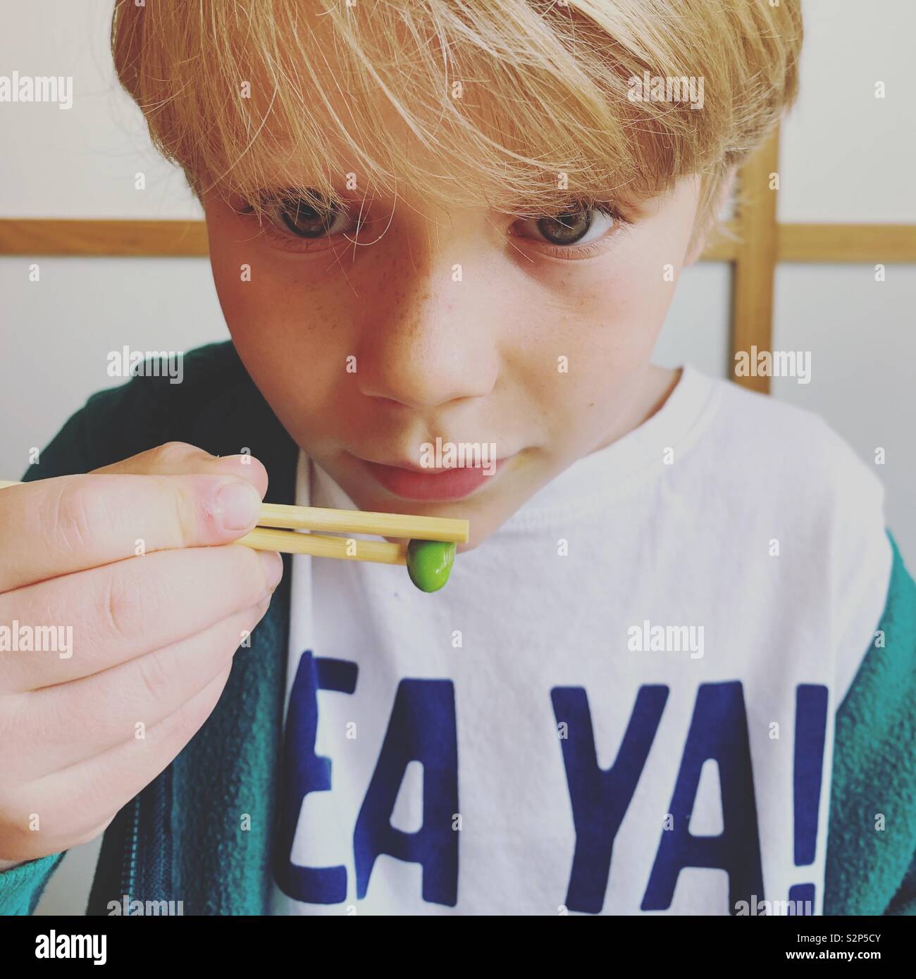 Boy using chopsticks Stock Photo Alamy
