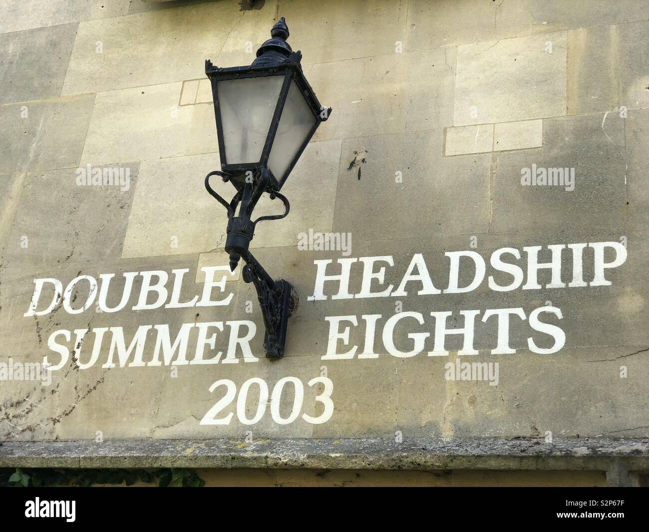 Oxford College rowing honours - Head of the River - displayed in Chalk letters on the wall of a  Quadrangle with an antique lamp and Cotswolds Ashlee stone wall. - Smartphone Captured Stock Image