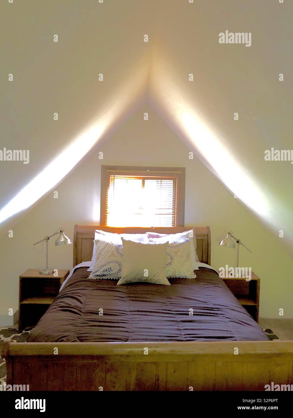 Cozy little love nest queen bed with pillows in an attic loft with