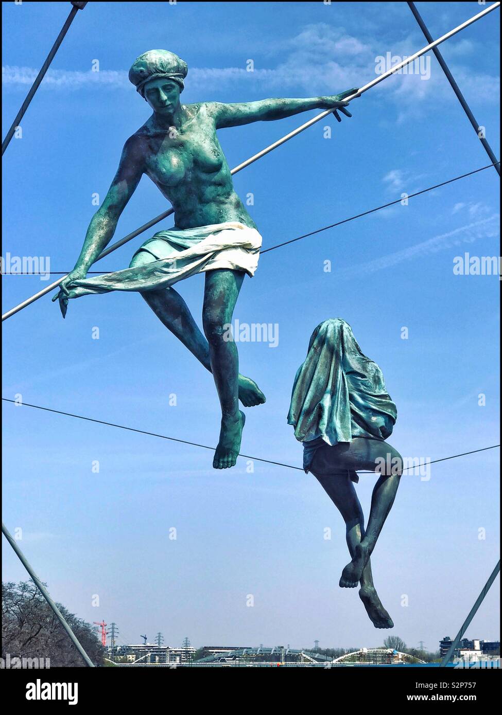 Two Sculptures balancing above the Vistula River & Father Bernatek Footbridge in Kraków, Poland. The bridge was opened in Sept. 2010. Sculptures by Jerzy Kędziora. © COLIN HOSKINS. - Smartphone Captured Stock Image