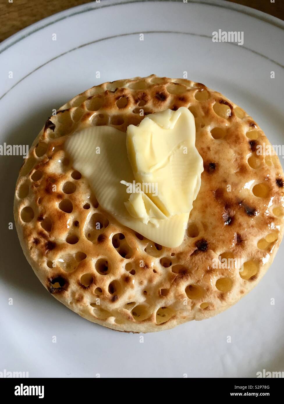 Butter on top of a crumpet Stock Photo