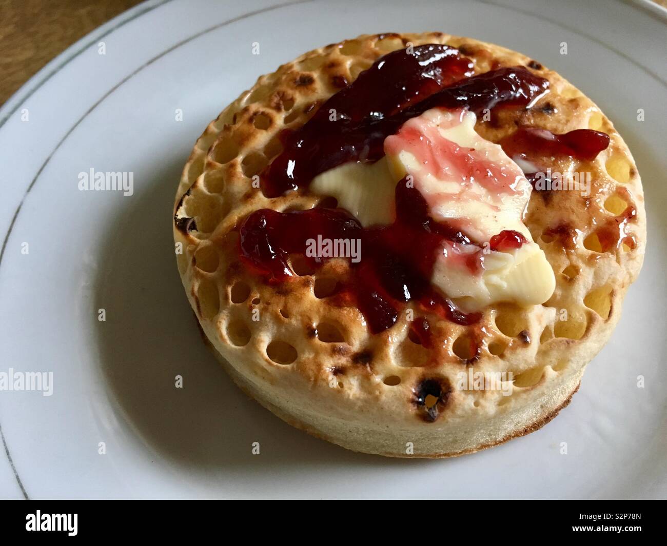 Jam and Butter on top of a crumpet Stock Photo