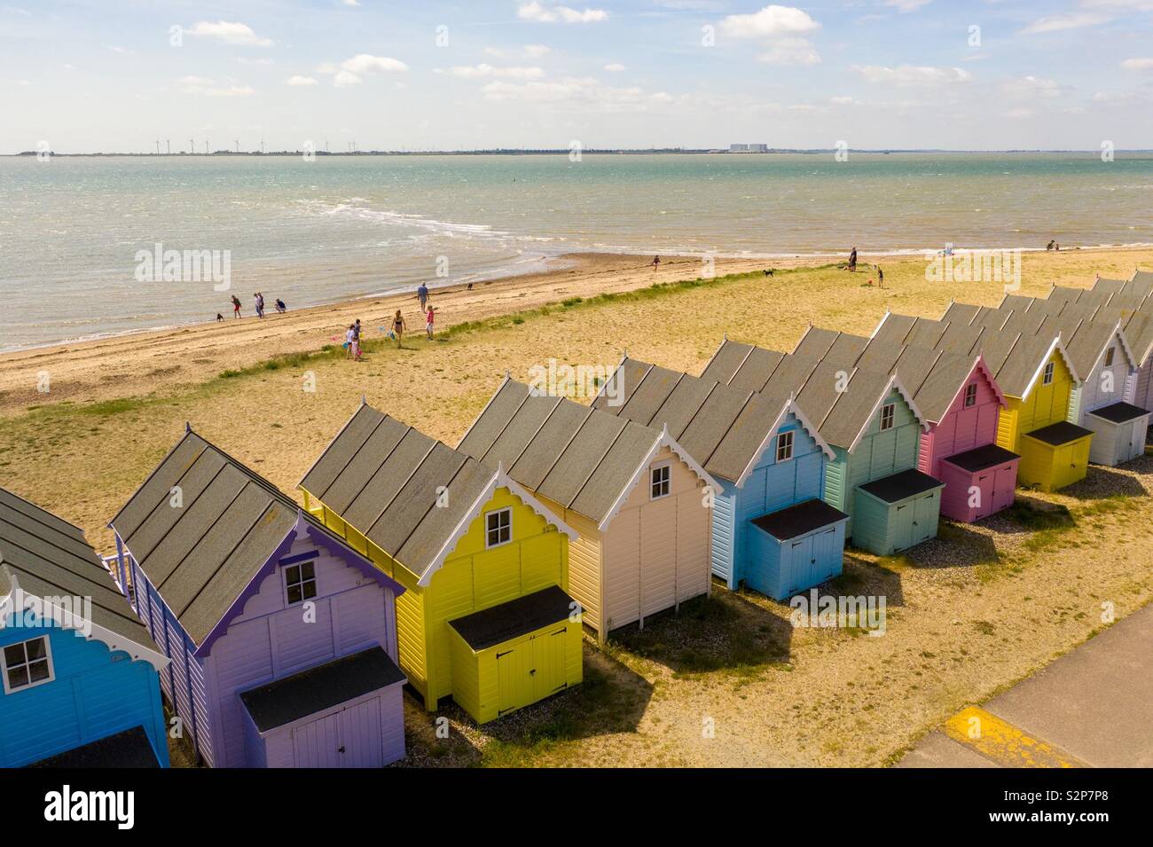Colourful beach huts shot aerially with beach, sea and people behind. - Smartphone Captured Stock Image