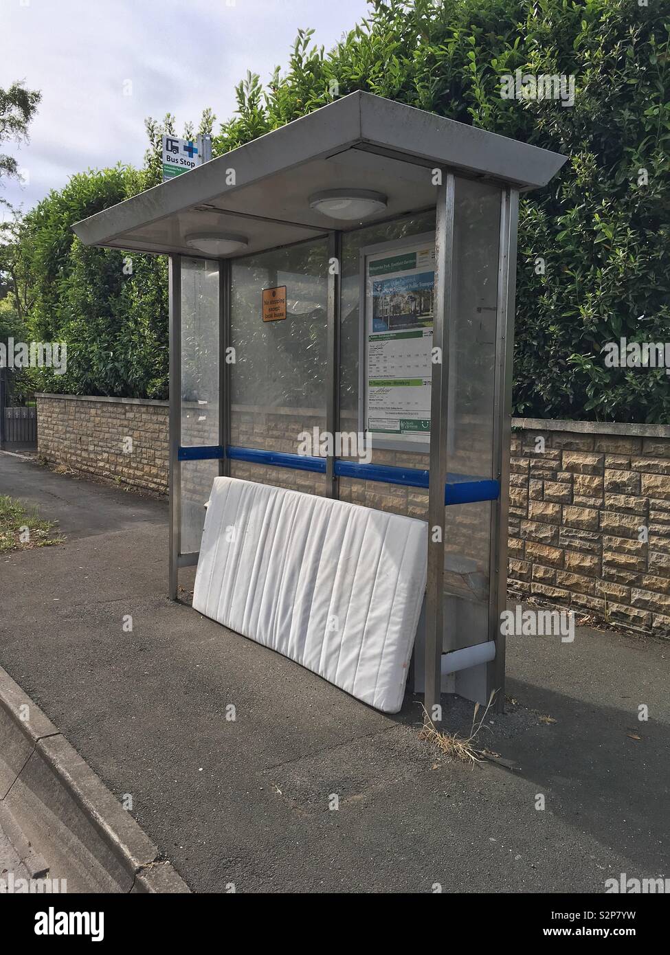 An old mattress dumped at a bus stop in Weston-super-Mare, UK - Smartphone Captured Stock Image