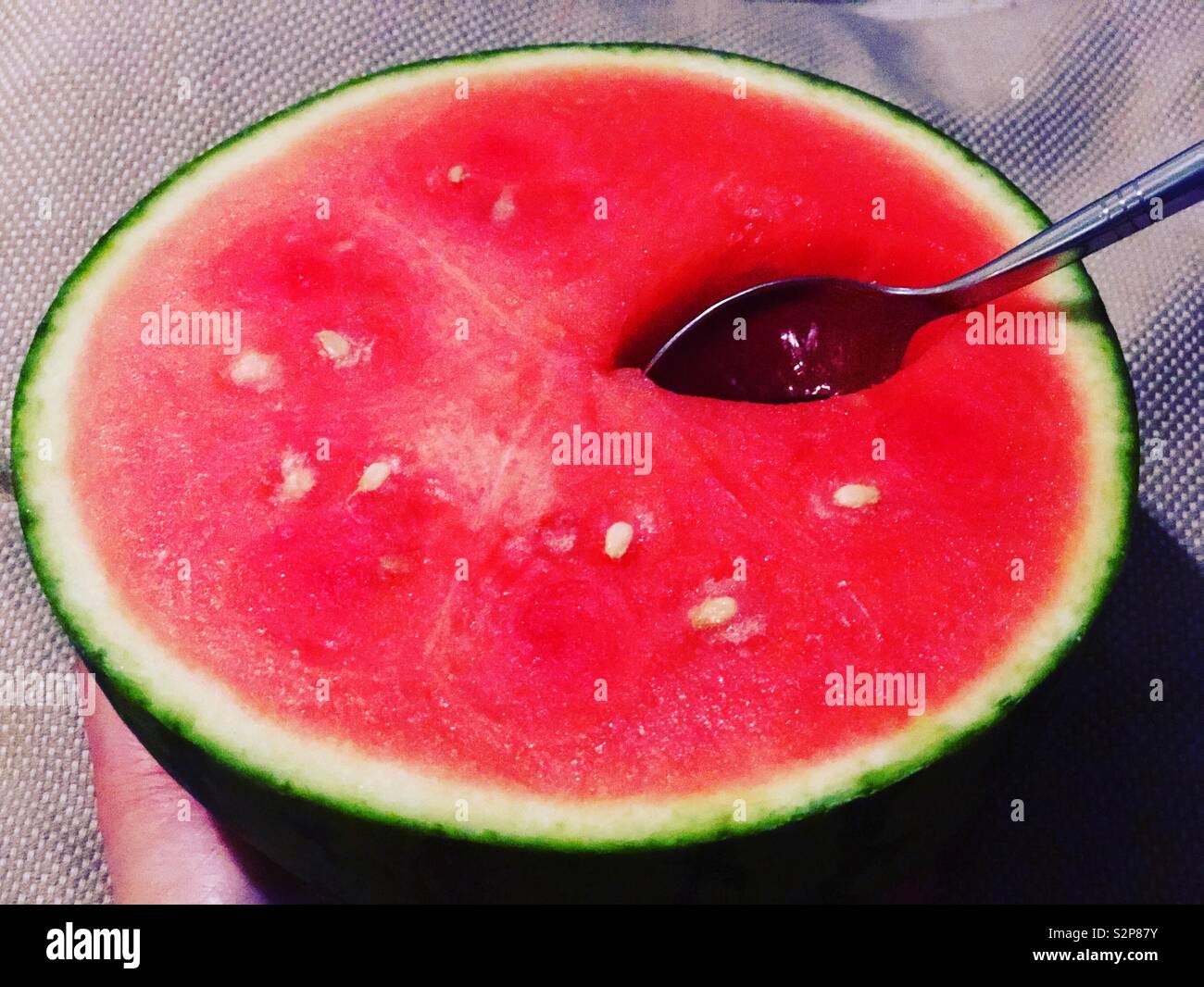 Taking a scoop out of half a watermelon with a spoon Stock Photo Alamy