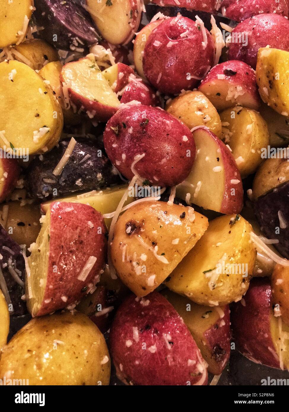 Medley of a variety of colorful potatoes cut and baked with fresh Parmesan cheese. - Smartphone Captured Stock Image