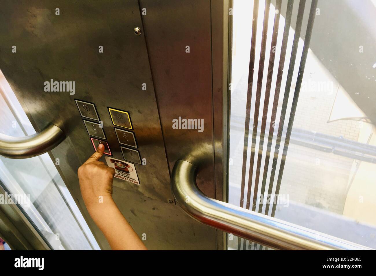 Child hand pushing button in lift - Smartphone Captured Stock Image