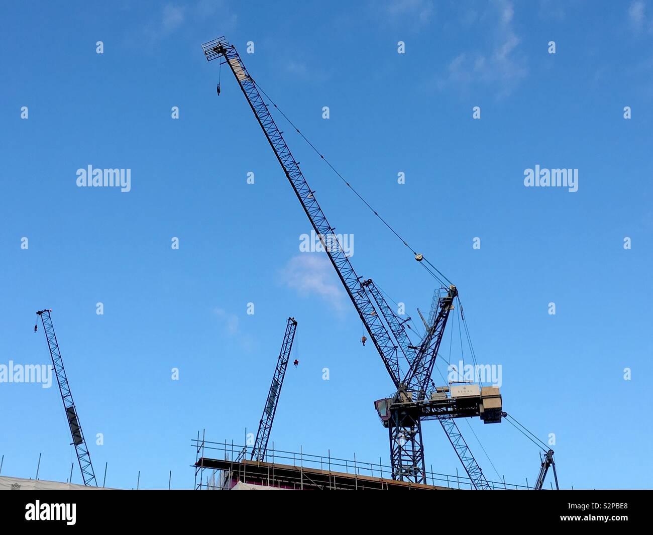 Building site cranes against a blue sky - Smartphone Captured Stock Image