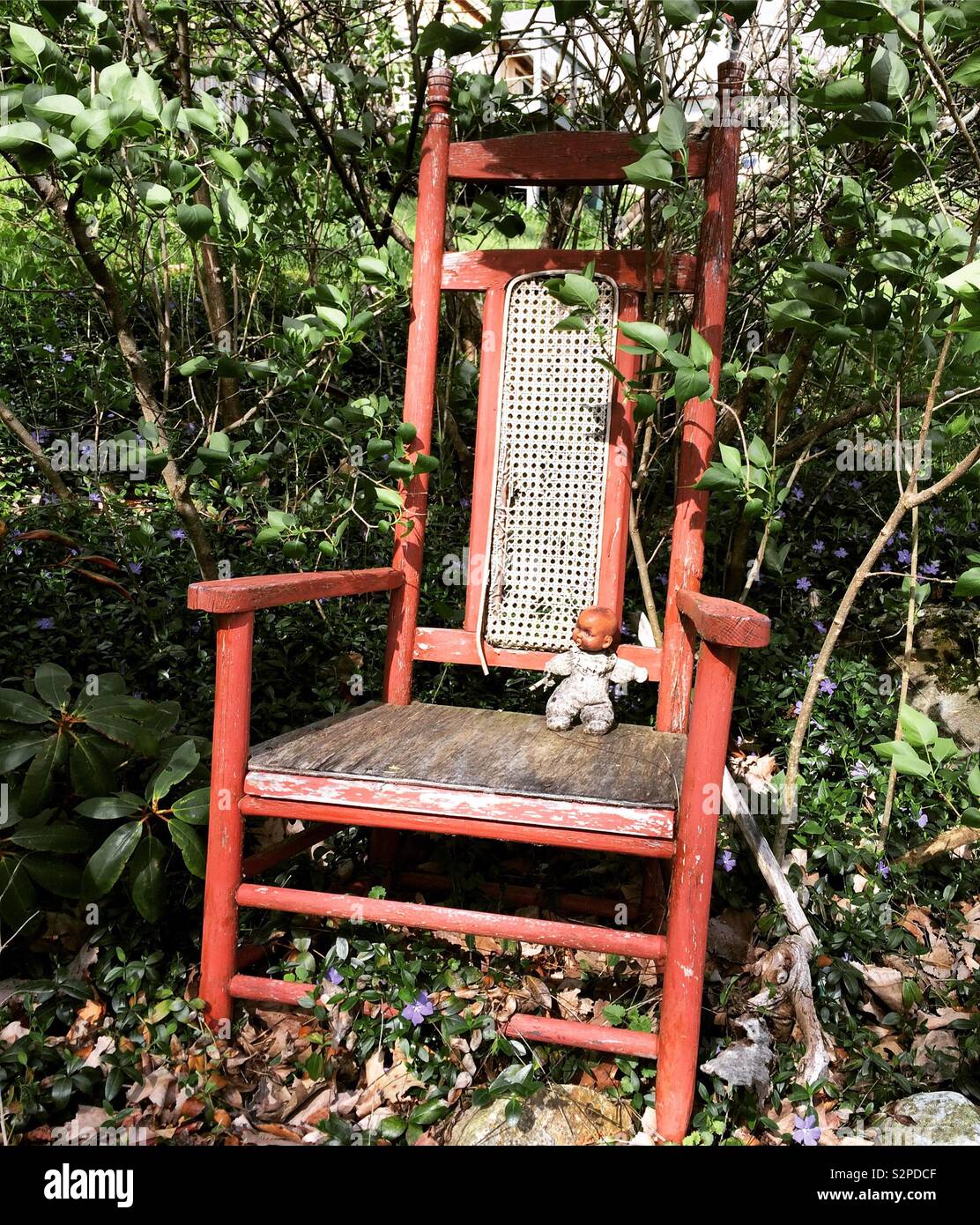 Doll in an old chair outside in springtime - Smartphone Captured Stock Image