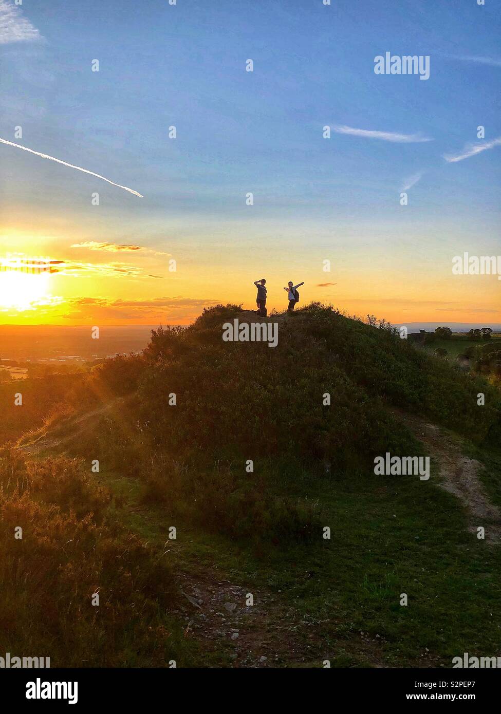 Children on top of a hill at sunset Stock Photo