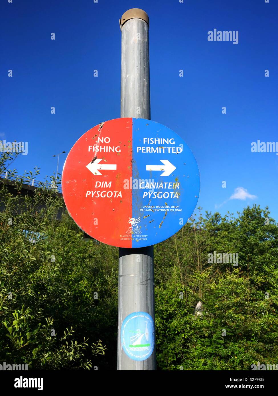 Bilingual Fishing / No Fishing sign in English and Welsh along the River Ely, Cardiff Bay, South Wales. Stock Photo