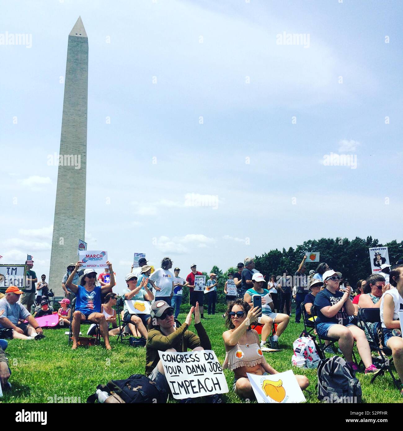 People listen to speakers on June 2, 2019, at the National March to Impeach Donald Trump, in Washington, D.C., United States - Smartphone Captured Stock Image