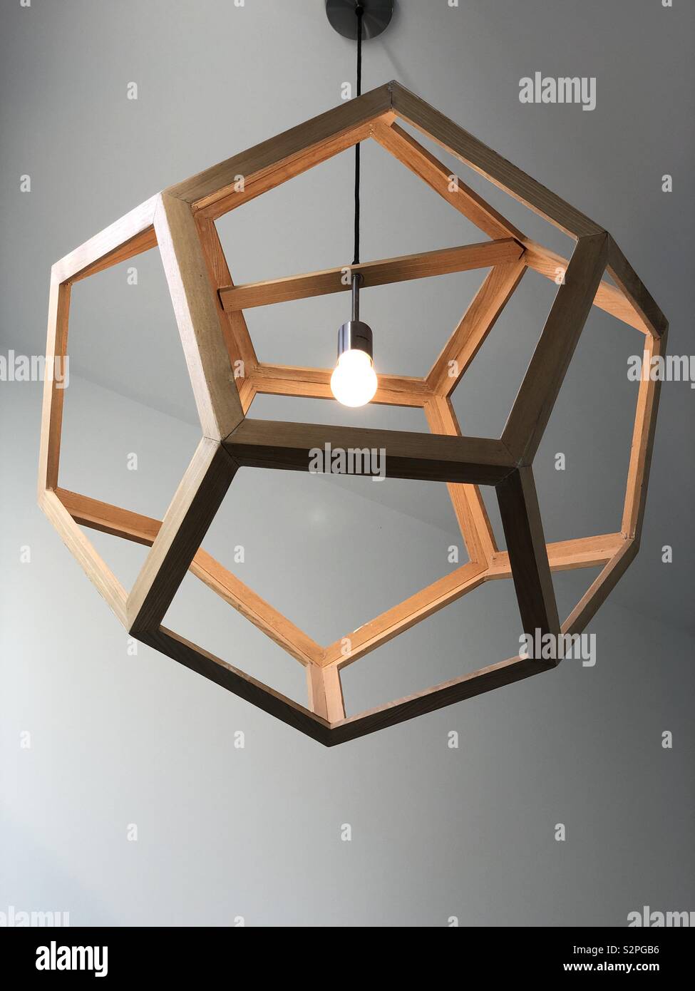 Pentagonal timber light hanging. Stock Photo