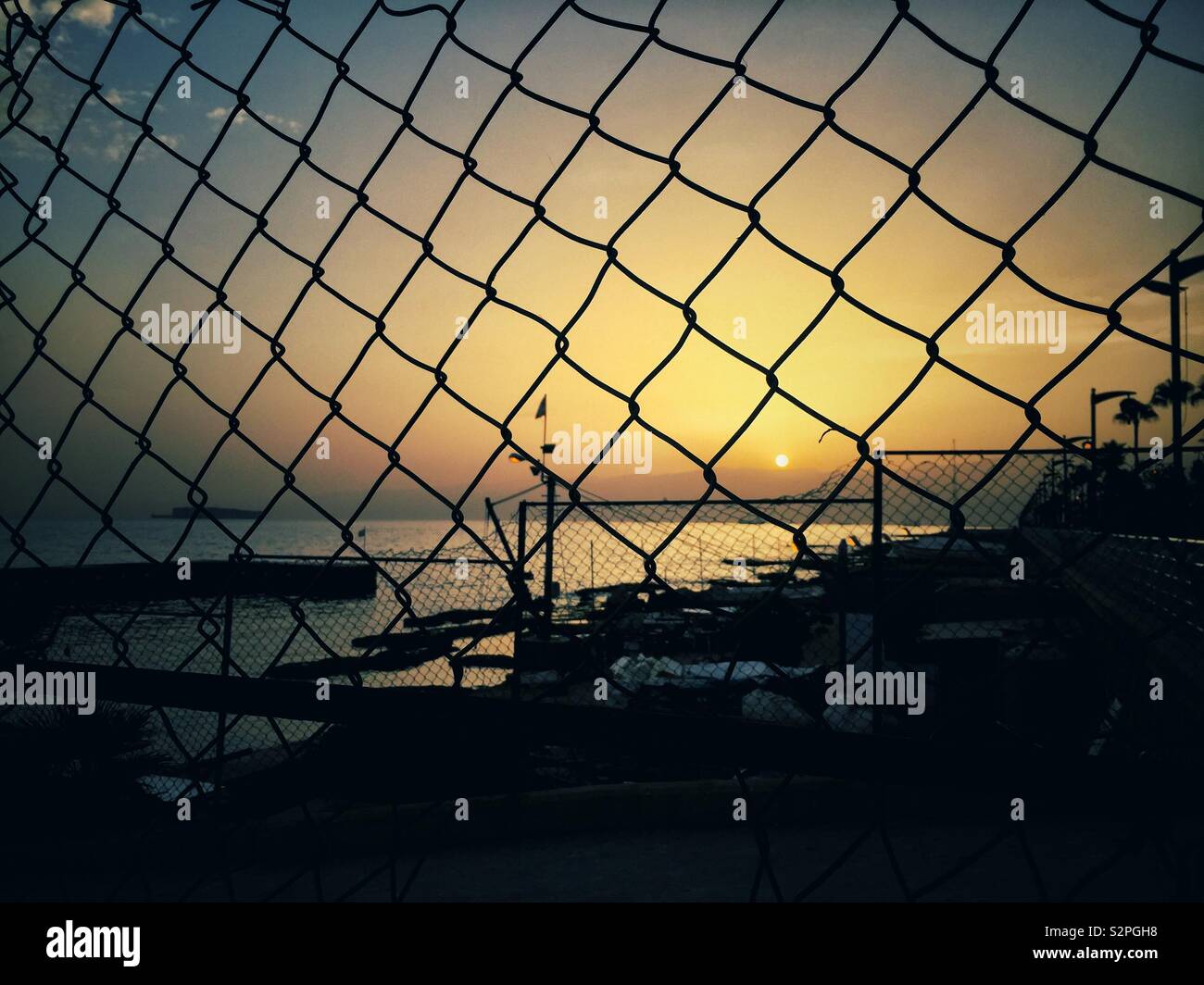 Chicken wire fence silhouette on the beach at sunrise Beirut Lebanon Middle East Stock Photo